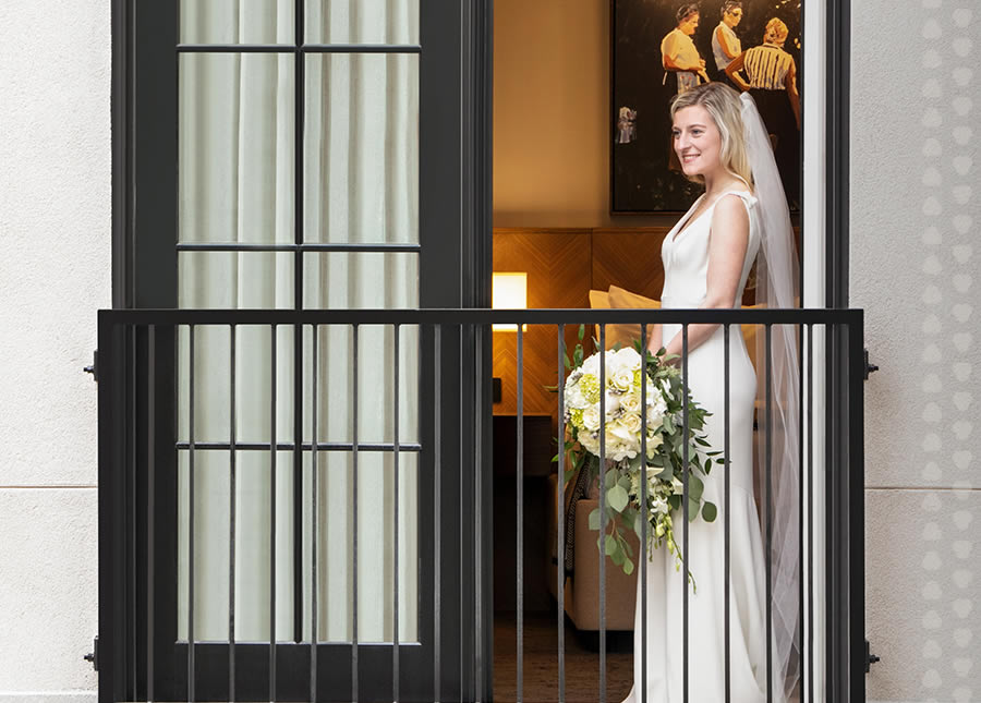 A bride looks out her balcony at The Harpeth Hotel (Franklin, TN)